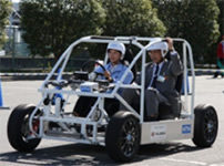 Photo: Iwata City Mayor Watanabe (right) and the test vehicle equipped with the In-wheel Motor System for Electric Commuters