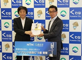 NTN President Ohkubo (left) presenting the record of donation to Kuwana City Mayor Ito (right)
